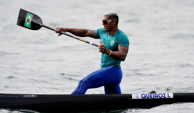 Homem negro usando camisa verde água e calça azul royal dentro de canoa segurando remo. Isaquias Queiroz venceu disputa na canoagem nesta sexta-feira (9) e ganhou medalha de prata