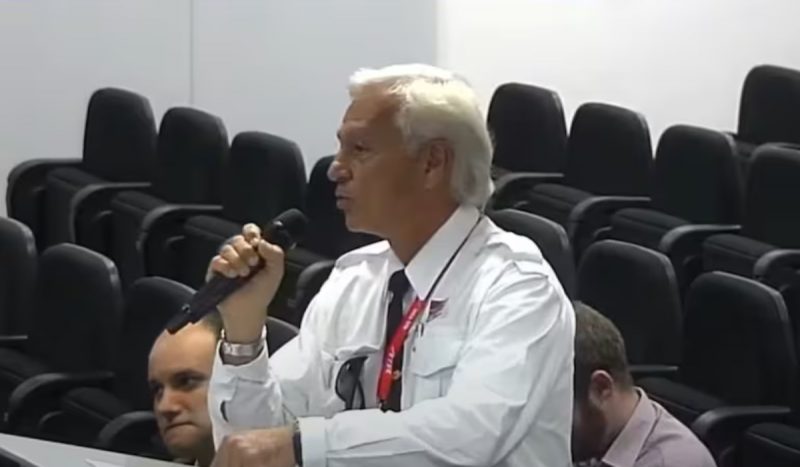 Piloto da Voepass falando em audiência da Anac - homem negro, grisalho, usando camisa social de mangas compridas branca com um microfone na mão