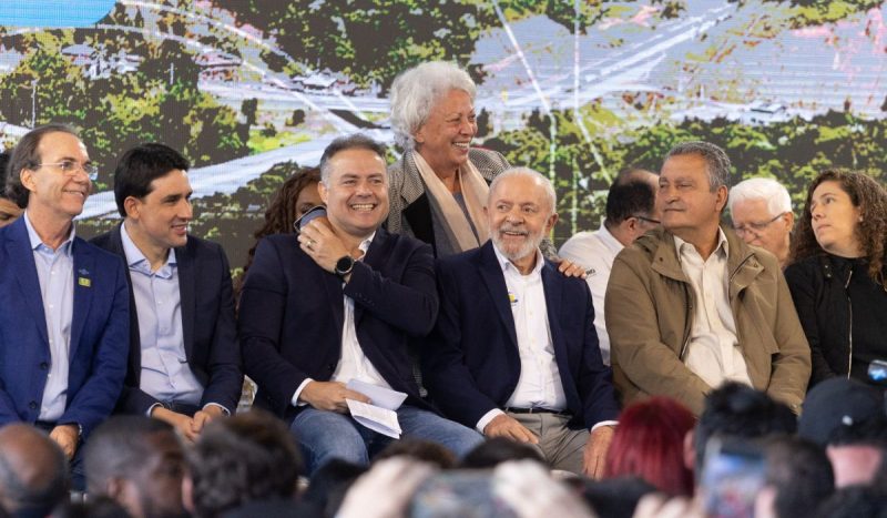 Renan Filho sentado à direita de Lula durante cerimônia de inauguração do Contorno Viário da Grande Florianópolis