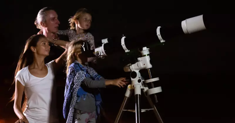 Família olhando por telescópio