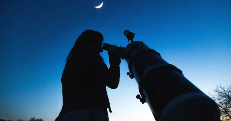 Mulher observando a lua com telescópio