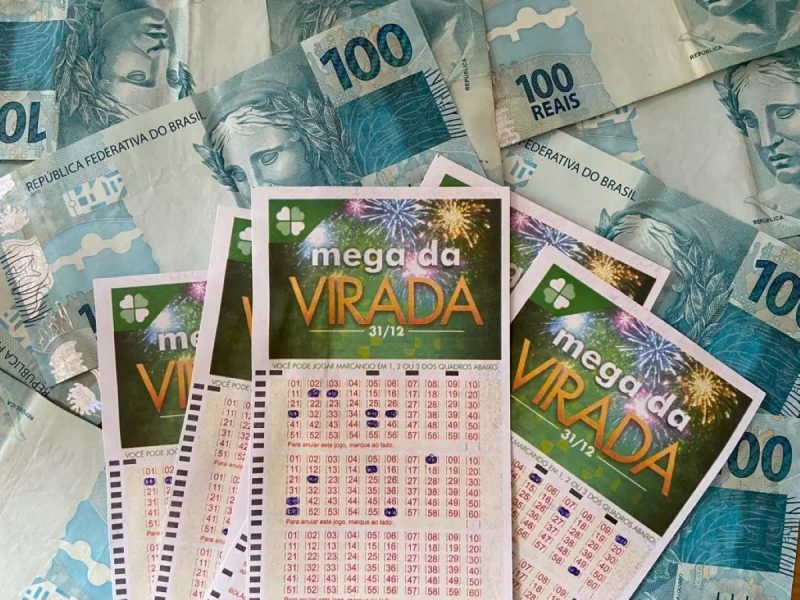 47 apostas levaram a quina da Mega da Virada em SC e passaram perto prêmio milionário. Na imagem, bilhetes da Mega da Virada e cédulas de R$100